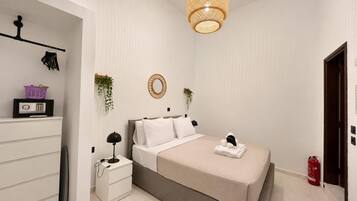 Una camera da letto con un letto, un comodino, una lampada e un lampadario.