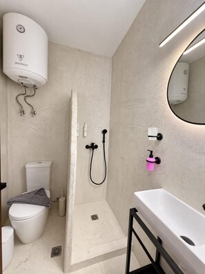 A modern bathroom with a shower, toilet, and sink. - Eternel Room 3 in Lindos (Rhodes)