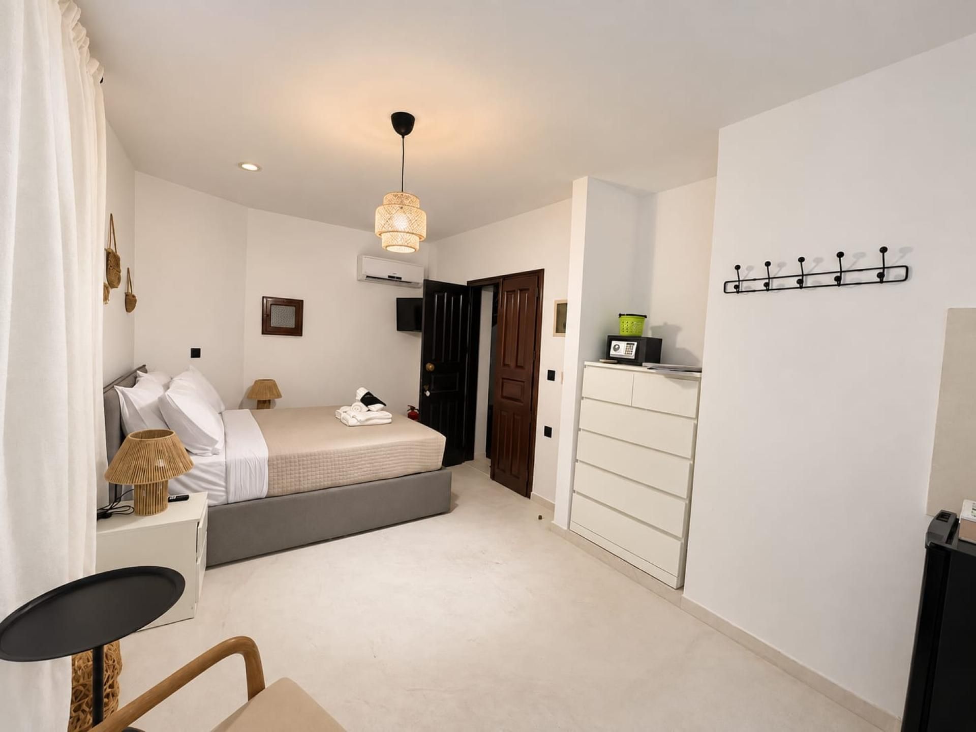 Une chambre à coucher moderne avec un lit, une table de chevet, une lampe et une armoire.