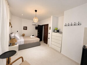 A modern bedroom with a bed, bedside table, lamp, and a wardrobe. - Eternel Room 4 in Lindos (Rhodes)