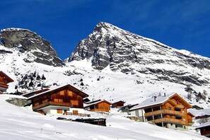 Ein mit Schnee bedeckter Berg mit Holzhütten.