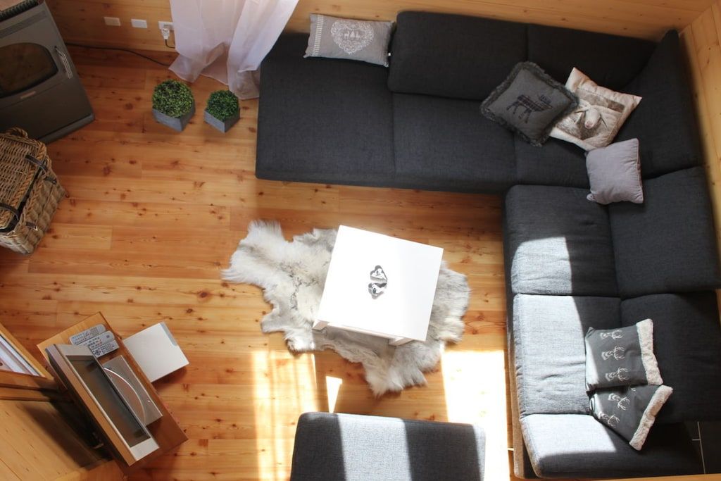 Ein gemütlicher Wohnbereich mit einer Couch, einem Fellteppich und einem kleinen Tisch mit einer Schachtel.
