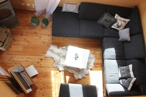 Uma sala de estar acolhedora com um sofá, um tapete de pele e uma pequena mesa com uma caixa.