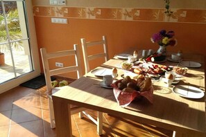 A dining table set with plates, cups, and a basket of bread. - Holiday apartment with 2 bedrooms (Hörnitz)