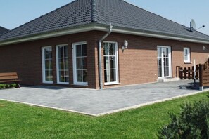A brick building with a tiled roof, large windows, and a paved entrance area. - Holiday home Stein in the Spreewald Lübbenau (Lübbenau)