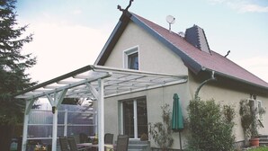 Una casa con portico coperto, un camino e un'antenna parabolica.