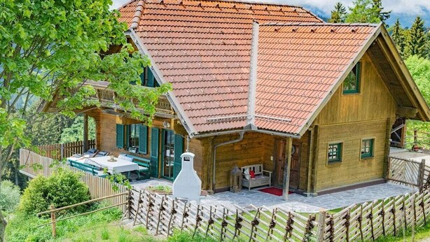 A wooden house with a sloped roof and a fenced yard. - Kogljahrerhütte || Prebl (Prebl)