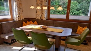 Un comedor con mesa, sillas y un banco.