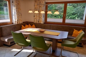 A dining area with a table, chairs, and a bench. - Holiday apartment with 3 bedrooms (Bramberg)
