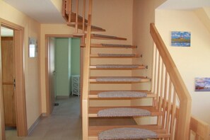A wooden staircase with carpeted steps leading to an upper floor. - Holiday home in Lancken with swimming pool (Lancken)