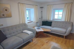 Ein Wohnzimmer mit zwei Sofas, einem Couchtisch, einer Stehlampe und einer Heizung.