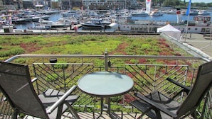A terrace with a table and chairs overlooking a marina with boats. - Holiday apartment in Waren with swimming pool (Waren)