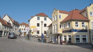 A street with buildings, a sign for 'Asia Buffet,' and a 'Klabattermann' restaurant. - Holiday apartment in Waren with swimming pool (Waren)