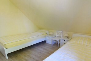 Ein kleines Schlafzimmer mit einem Bett, einem Schreibtisch und einem Stuhl.