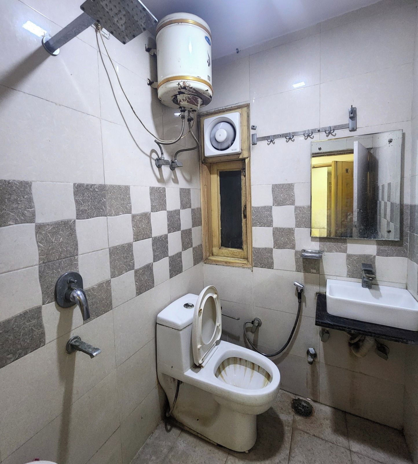 Uma casa de banho pequena com sanita, lavatório e espelho.
