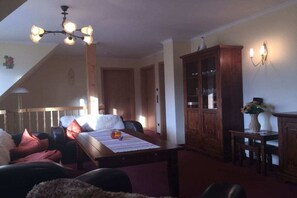 Ein gemütliches Wohnzimmer mit Esstisch, Stühlen, Kamin und einem Holzschrank.