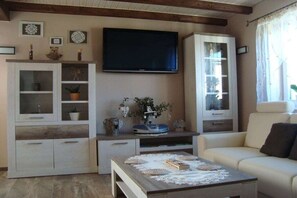 A living room with a television, cabinets, a sofa, and a coffee table. - Holiday home with 2 bedrooms (Rosenthal-Bielatal OT Bielatal)