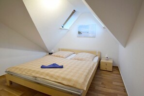 A bedroom with a single bed, a nightstand, a bedside lamp, and a window with a view of the outdoors. - House "Am Brunnen" Where 7 (Ostseebad Prerow)