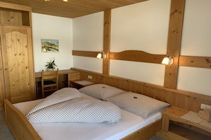 A wooden room with a bed, a desk, and a chair. - in the Witting house (Leutasch)
