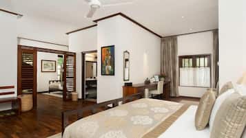 Un dormitorio con cama, escritorio, silla, espejo y ventana.