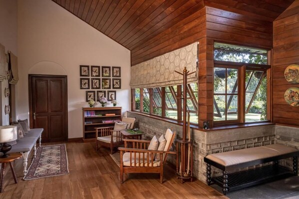 A cozy room with wooden walls, a bench, a sofa, and a bookshelf.