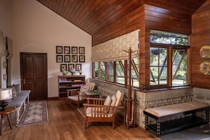 Una habitación acogedora con paredes de madera, un banco, un sofá y una estantería.