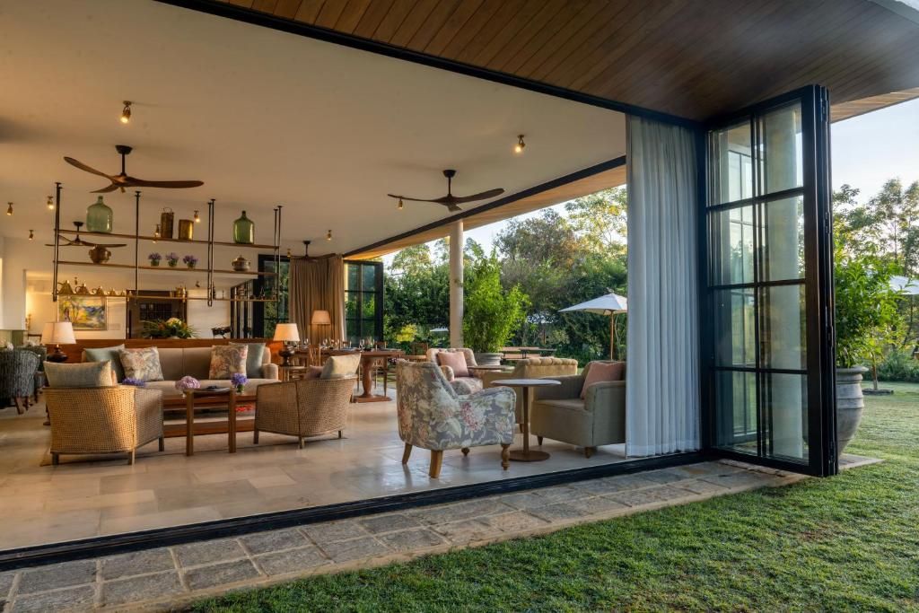 Un espacio interior amplio con un conjunto de asientos, una cocina con estantes, y un ventanal que ofrece vistas al exterior.
