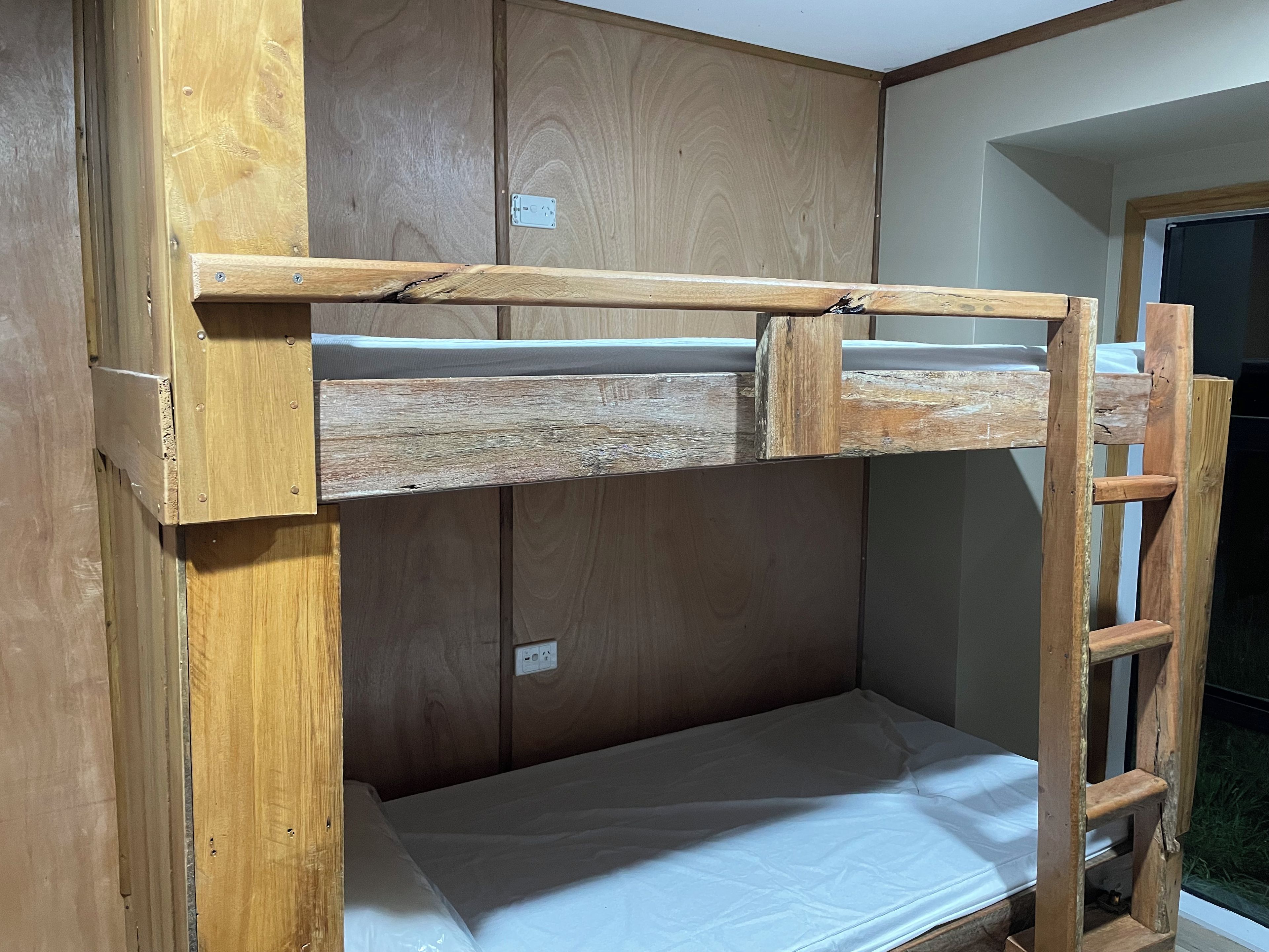 A bunk bed with a wooden frame and a mattress.