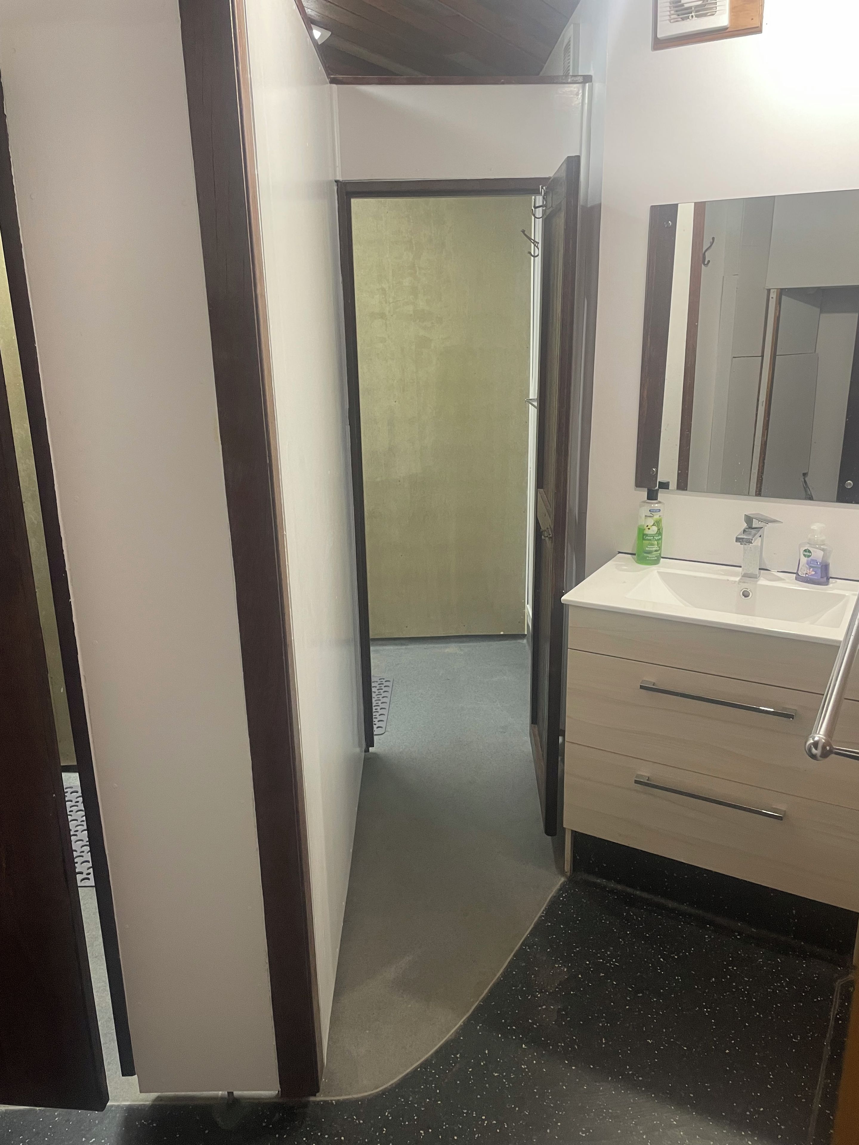 A bathroom with a sink, mirror, and toiletries.