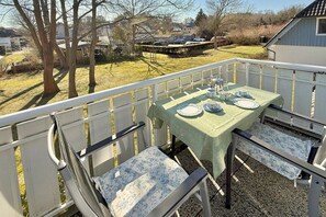 Ein Balkon mit Tisch für zwei Personen, Stühlen und Blick auf die Umgebung.
