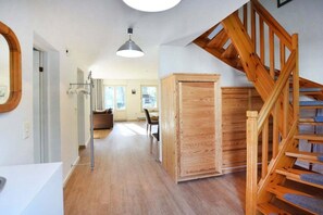 A spacious hallway with a wooden staircase and a large cabinet. - Holiday home with 3 bedrooms (Ostseebad Prerow)