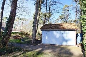 A small, single-story building with a tiled roof and two garage doors. - Holiday home with 3 bedrooms (Ostseebad Prerow)