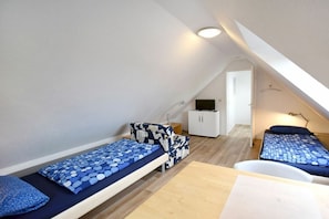 A small, compact room with two beds, a white cabinet, and a desk. - Buchengrund W 4 || Ostseebad Prerow (Ostseebad Prerow)