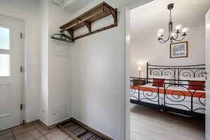 Ein Zimmer mit einem Bett, einer Kristallleuchtre und einem Holzregal.