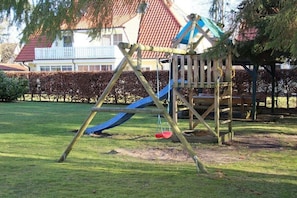 A playground with a slide and climbing structures. - Holiday home in Prerow with swimming pool (Prerow)