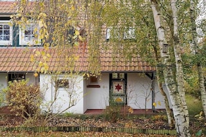 A building with a tiled roof, a white facade, and a front door with a star-shaped decoration. - Holiday home in Prerow with swimming pool (Prerow)