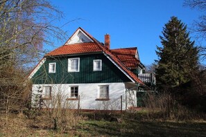 A two-story house with a red-tiled roof, white and green exterior walls, and a chimney. - Holiday home in Prerow with swimming pool (Prerow)