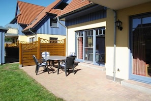 A residential property with a patio, a wooden gate, and a sliding glass door. - Grüne Str. 36 h "Seenadel" (Prerow)