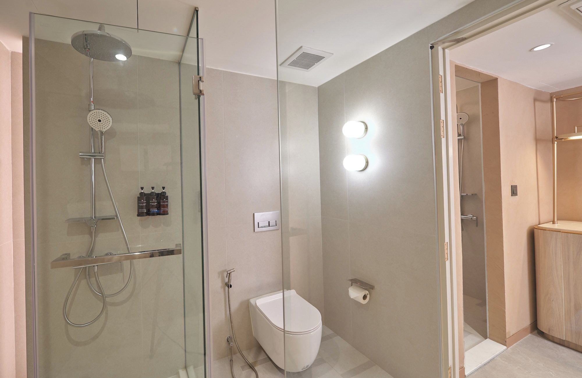 Ein modernes Badezimmer mit einer gläsernen Dusche, einer Toilette und einem Waschtisch mit Spiegel.