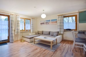 Ein Wohnzimmer mit einer Couch, einem Couchtisch und einem Essbereich mit Stühlen.