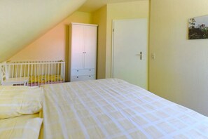 Ein Schlafzimmer mit einem Bett, einem weißen Wandschrank und einer Tür.