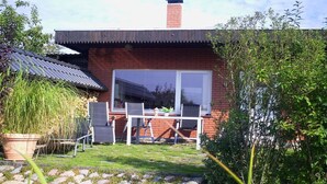 A brick house with a patio, a table, and chairs. - Holiday home with 1 bedroom (Waren \/ Müritz)