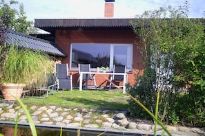 Una casa de ladrillo con un patio, una mesa y sillas.