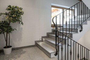 Eine Treppe mit Metallgeländer und einem Blumentopf daneben.