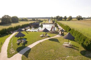 A riverside area with a walking path, picnic tables, and umbrellas. - Holiday apartment with 3 bedrooms (Märkische Heide OT Biebersdorf)