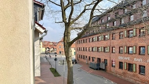 A street view with a red brick building labeled 'EISCAFE BAR' and a tree in the foreground. - Holiday apartment with 2 bedrooms (Waren (Müritz))