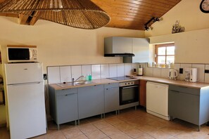 Une cuisine compacte équipée d’un four à micro-ondes, d’une cuisinière, d’un évier et d’un lave-vaisselle.