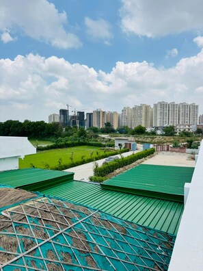 A residential area with high-rise buildings in the background, a green lawn, and a construction site.