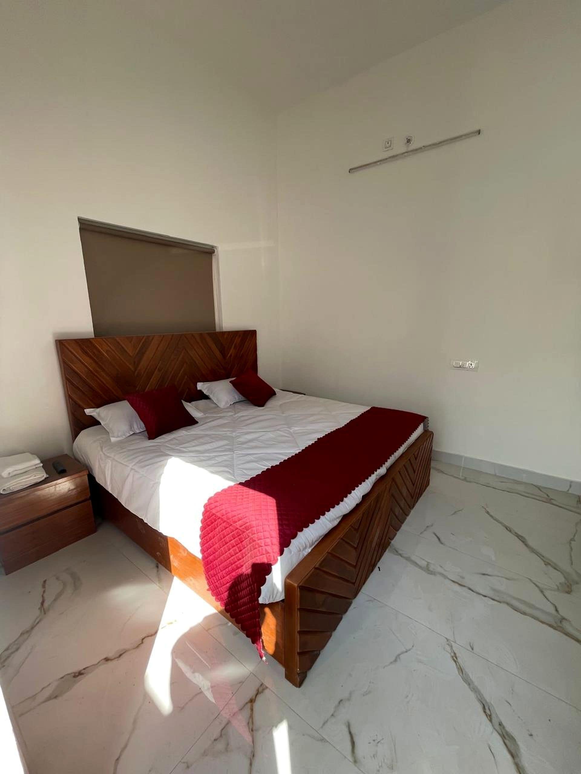 Un dormitorio con cama, mesita de noche y cabecera.