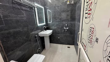 Ein Badezimmer mit weißem Waschbecken, einem Spiegel, einer Dusche und einer Toilette.